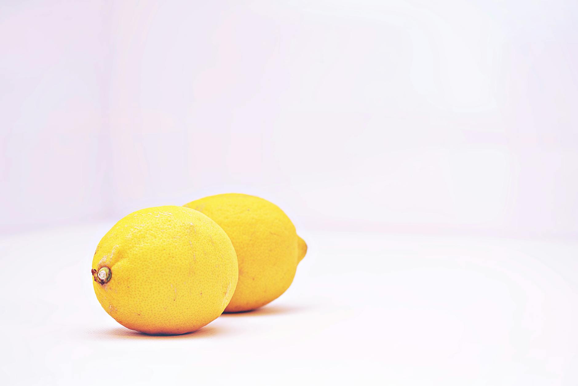 Two vibrant lemons on a white background symbolizing fresh sensation and reconnection