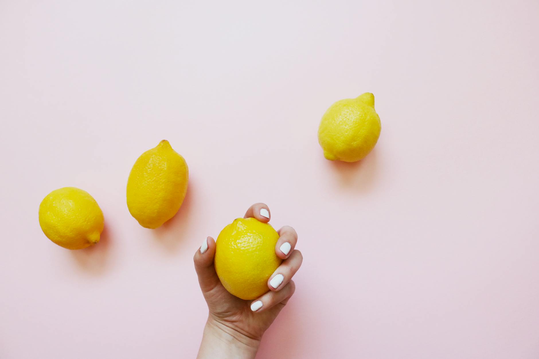 Close-up of hands holding a lemon-colored personal massager against a knitted sweater.