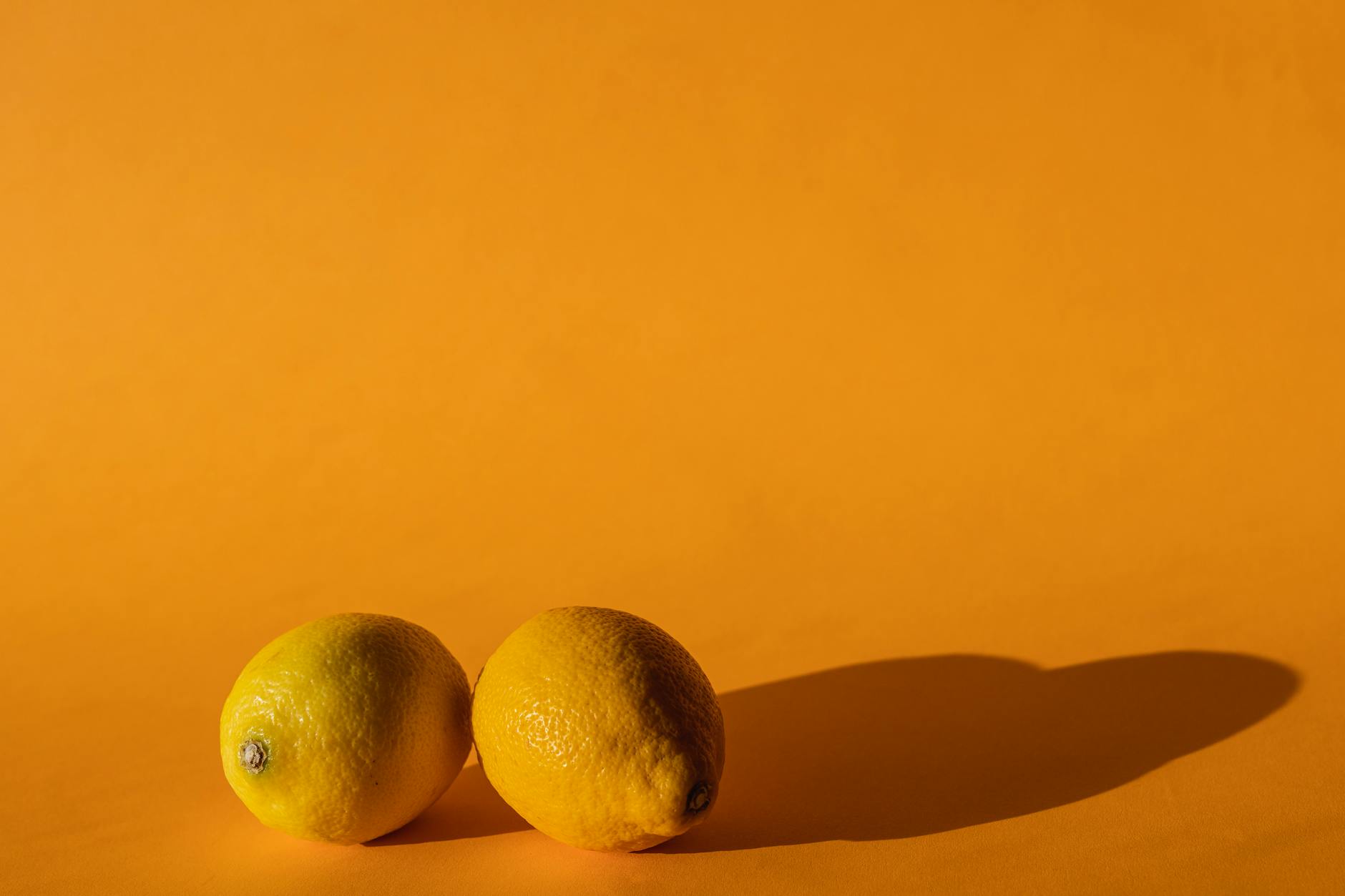Vibrant lemons on a bright yellow background, symbolizing returning warmth and sensuality after loss